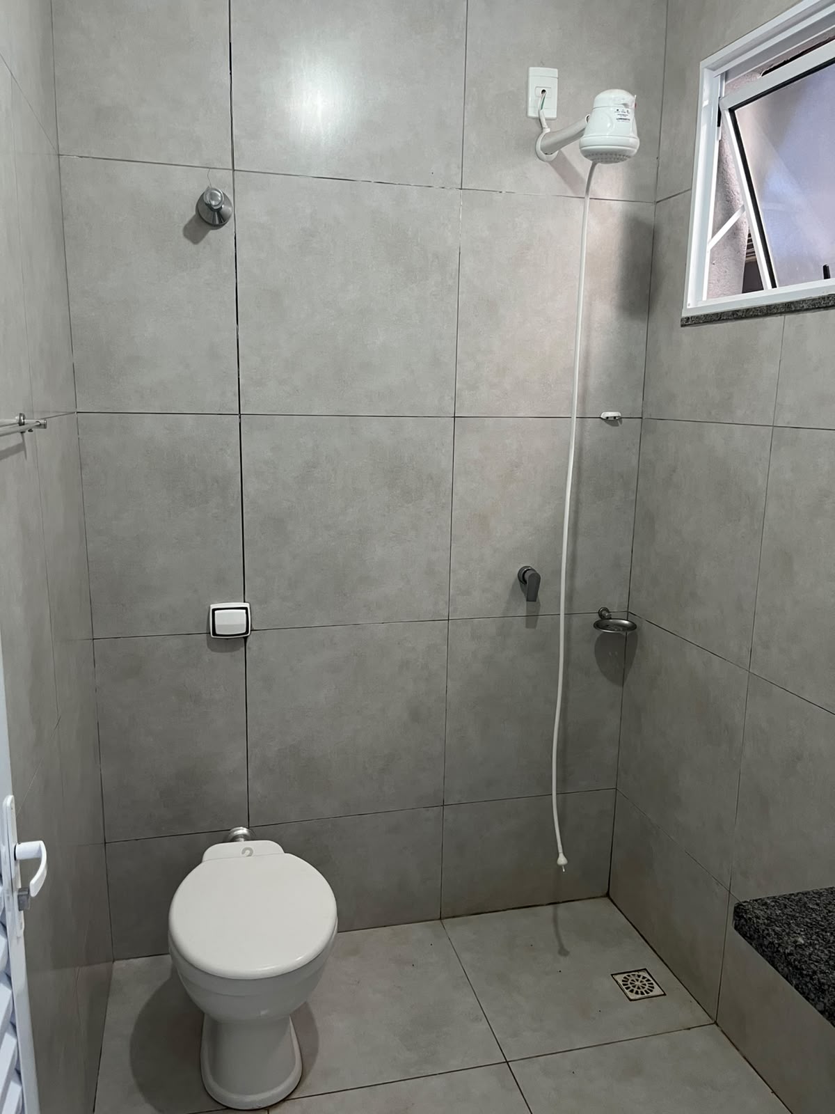 Banheiro com chuveiro e janela