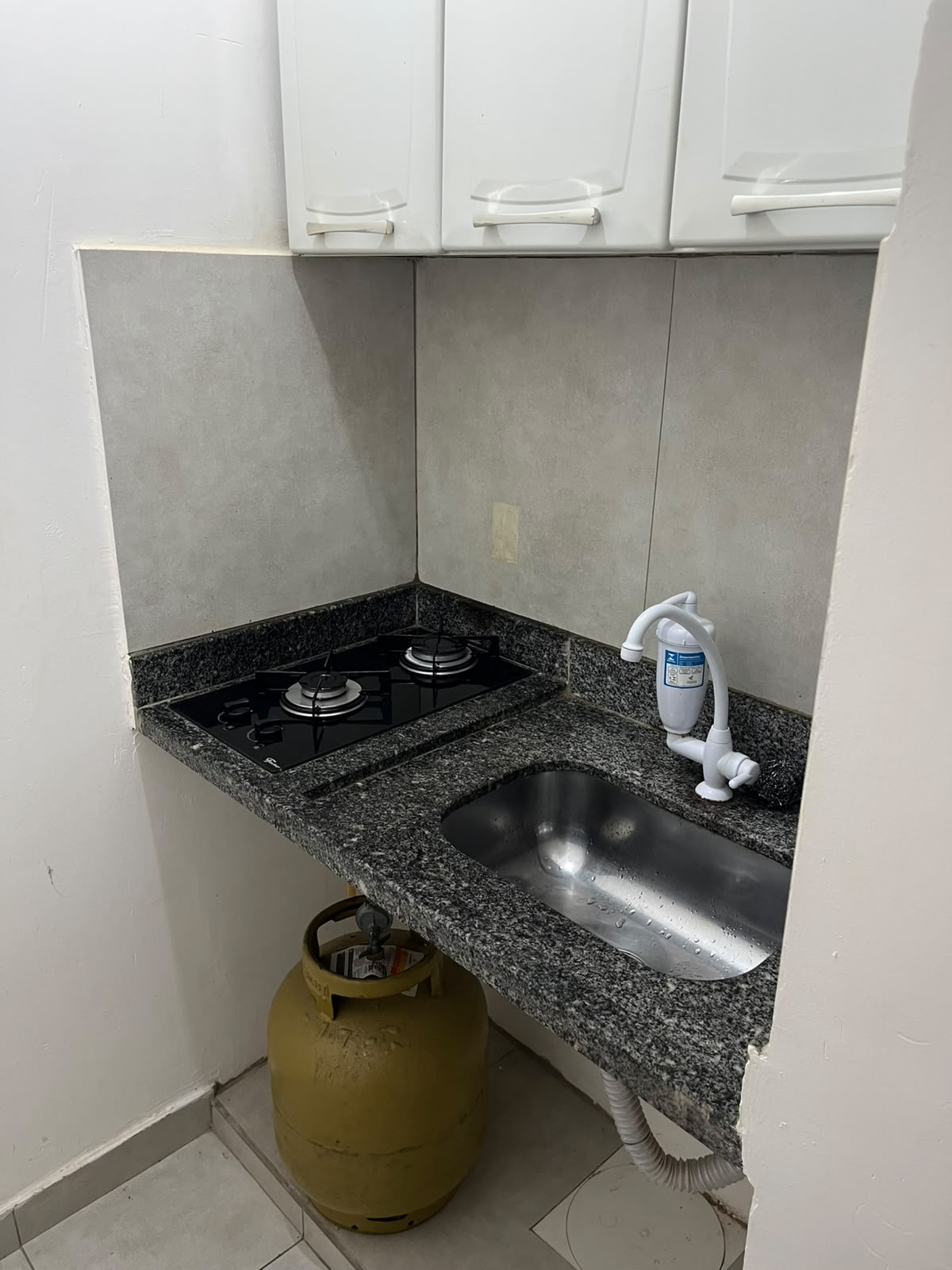 Cozinha com cooktop e pia em granito