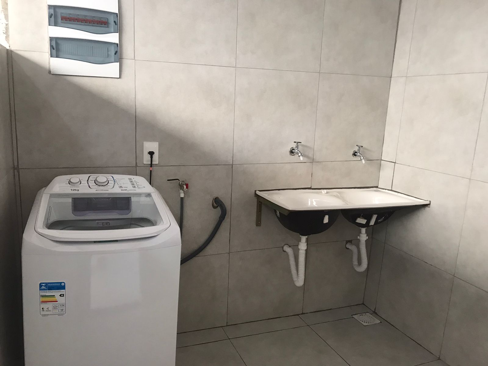 Área de serviço com máquina de lavar