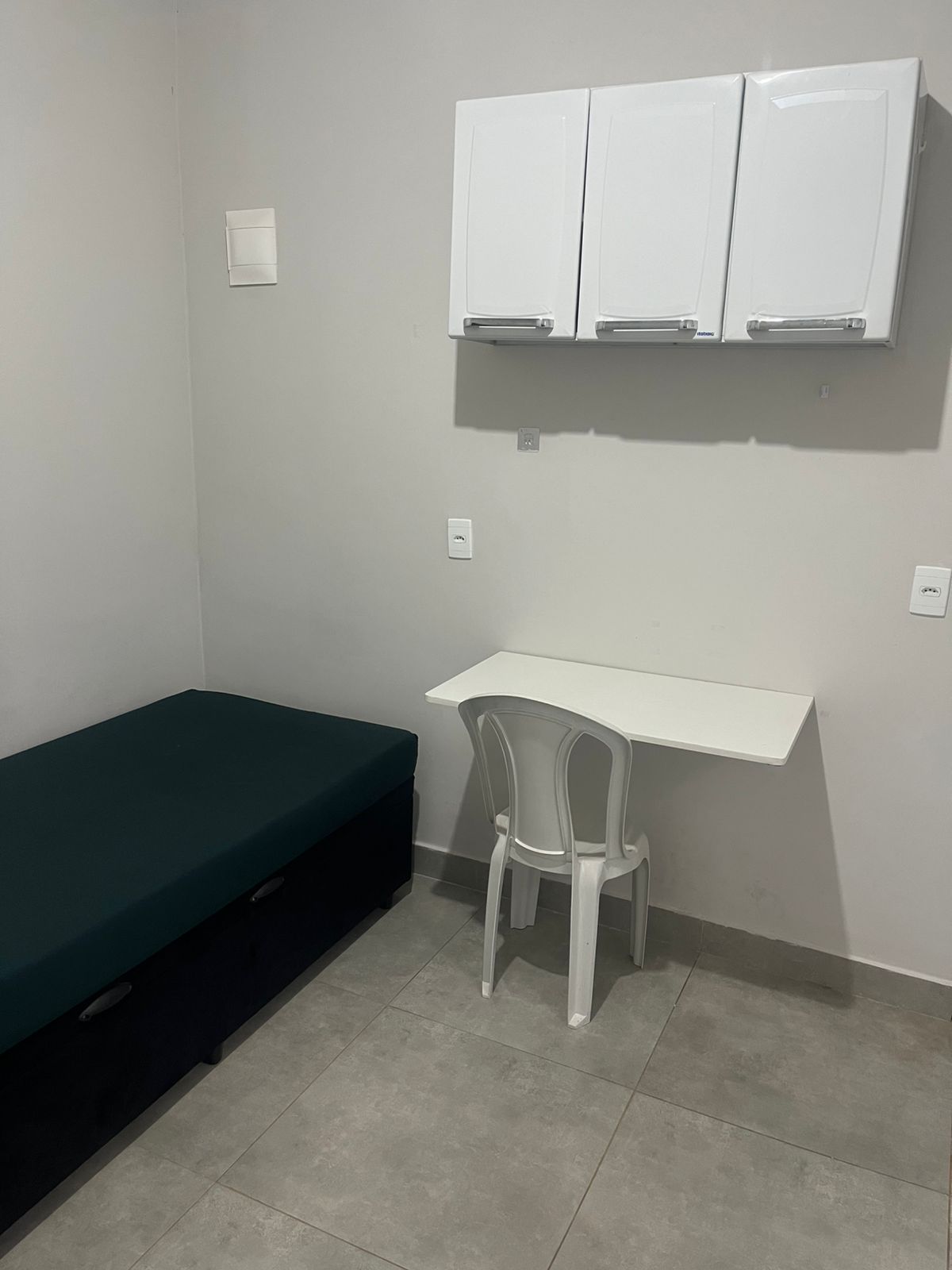 Cama, mesa e armários aéreos